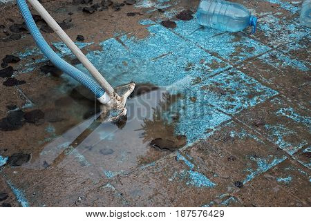 Swimming pool sludge removal with a vacuum cleaning brush and hose
