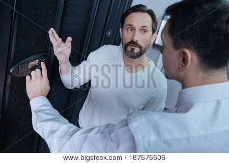 Our workplace. Pleasant nice adult men working and talking to each other while working together in the data center