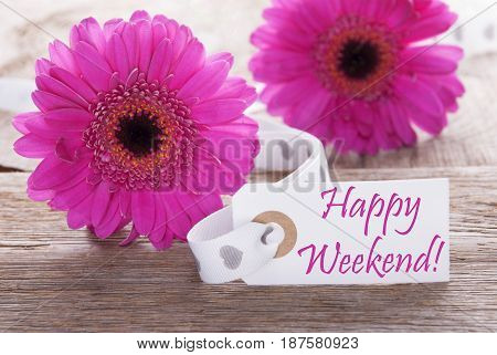 Label With English Text Happy Weekend. Pink Spring Gerbera Blossom. Vintage, Rutic Or Aged Wooden Background. Card For Spring Greetings.