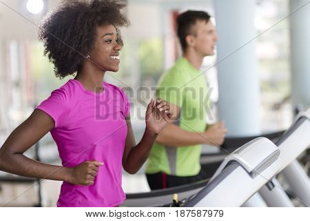 young people exercisinng a cardio on treadmill running machine in modern gym