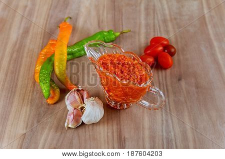 Raw hot georgian sauce adjika and ingredients on a wooden table adjika