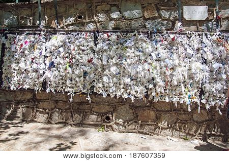Wishing wall with tied note petitions to the Virgin Mary saint and Mother of God at her restored house near Ephesus Turkey