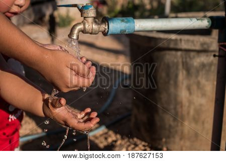 Close up Asian children wash hands Water shortage concept.