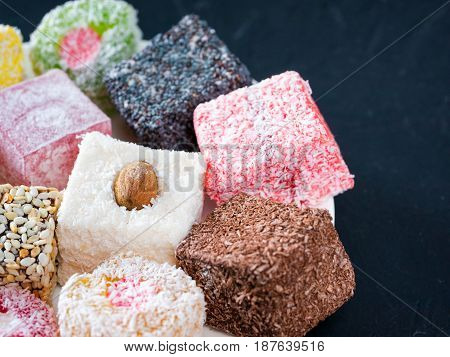 Turkish delight on black rustic background. Turkish deligh set. Assorted traditional turkish delight on oriental dark background