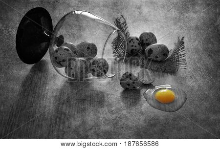 Quail eggs on the table. Broken quail egg. Black and white still life with quail eggs.