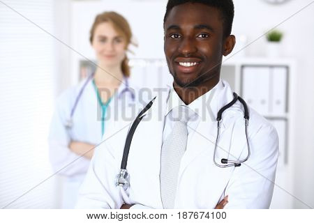 Happy african american male doctor with medical staff at the hospital.