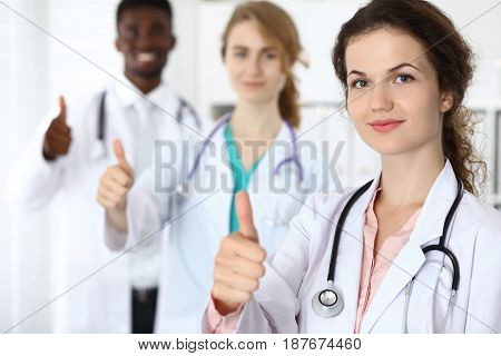 Medical team of confident doctors showing Thumbs up sign and ready to help. Medicine and health care, insurance concept.