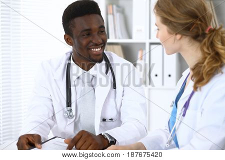 Happy african american male doctor with medical staff at the hospital.