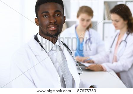 Happy african american male doctor with medical staff at the hospital.