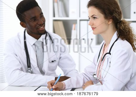 Happy african american male doctor with medical staff at the hospital.