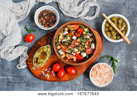 Spring vegetable salad with arugula cherry tomatoes chickpeas olives and feta cheese. Healthy vegan detox food. Top view