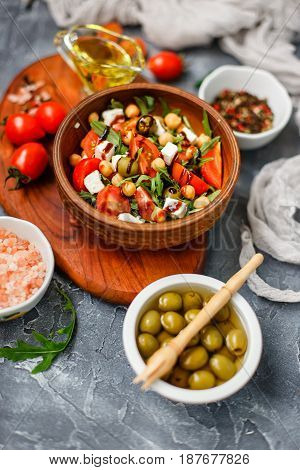 Spring vegetable salad with arugula cherry tomatoes chickpeas olives and feta cheese. Healthy vegan detox food. Buddha bowl. Shallow depth of field.