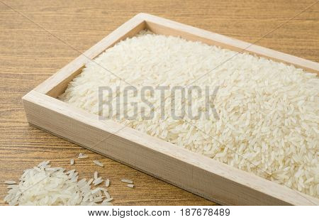 Cuisine and Food Uncooked White Long Rice Basmati Rice or Thai Jasmine Rice in Wooden Tray.