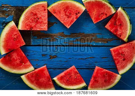 Sliced watermelon Top View. Many slices on an old rustic blue table. Side composition with copy space. Food Backrgound.