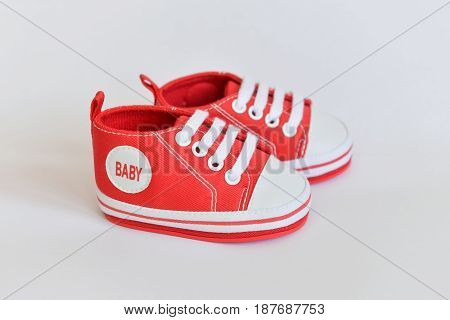 Red sneakers Baby shoes for newborns on isolated background