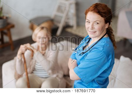 Skillful worker. Proficient enthusiastic private doctor providing medical examination and diagnosing elderly people while they not leaving their apartment