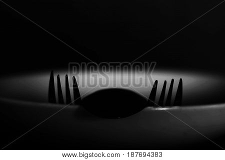 Spoon And Fork On Empty Plate In White Tone, Diet, Poverty Or Afraid Of Eating Concept