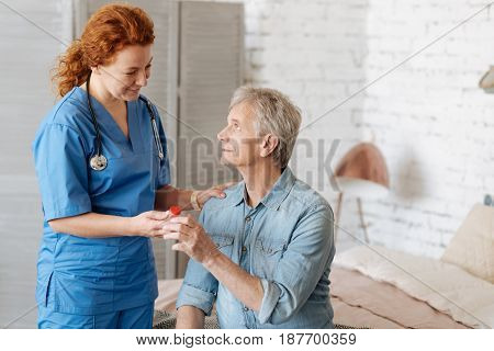 Thank you for helping me. Delicate trained professional woman taking care of elderly gentleman while paying him a visit and bringing needed medication