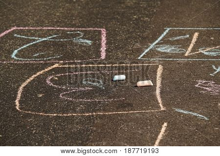 Colorful drawing chalk on an asphalt road in summer