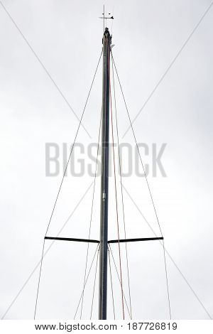 mainmast of a sailboat moored in the harbor