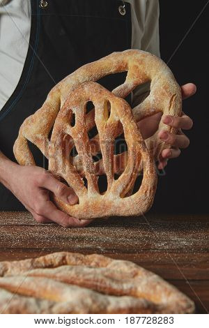 Baker is holding fougas bread