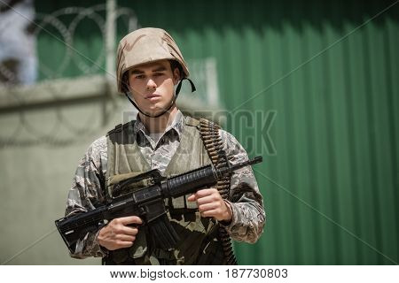 Military soldier standing with a rile in boot camp