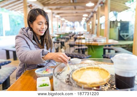 Young woman having somen in restaurant