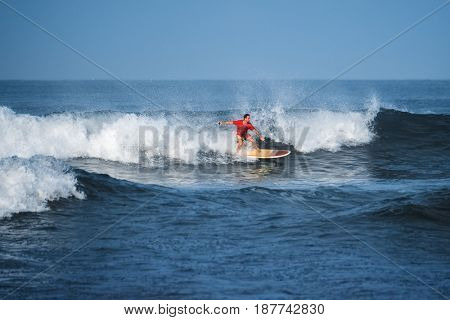 Amateur surfer rides the wave in the ocean