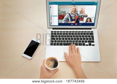 Woman video conferencing with plumber on laptop. Online service concept