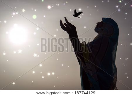  Copy space of silhouette woman rising hands on sunset sky double exposure colorful bokeh and bird fly background. Vintage tone filter effect color style.