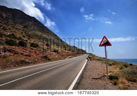 Warning sign in a red triangle on a mountain road