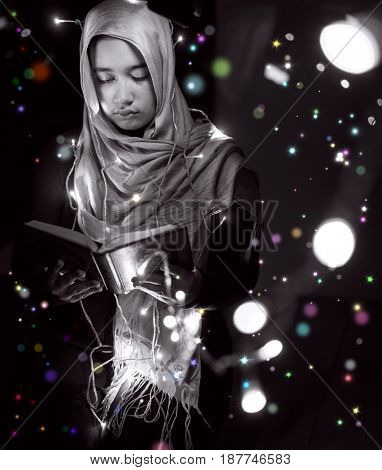 Muslim woman praying in dark room with nice lights around her