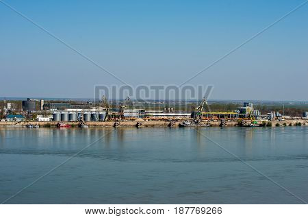 Cargo port with warehouses and industrial area on the banks of the river