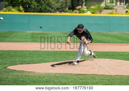 Mens' baseball pitcher throwing the curveball with maximum spin.