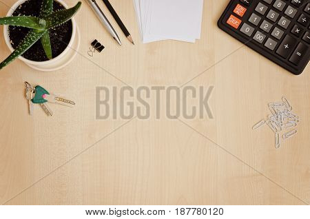 Top view office desk with paper for notes calculator indoor plant and keys. Copy-space composition