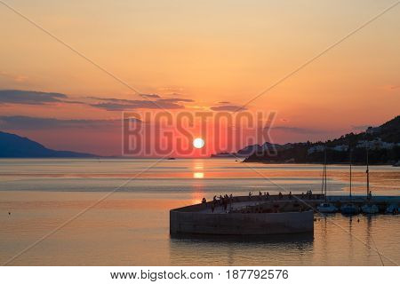 Sun setting down over the sea, The red disc of the sun touches the horizon.