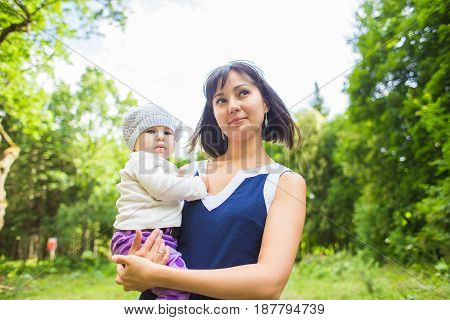 Mixed race happy mother with baby girl outdoors portrait.