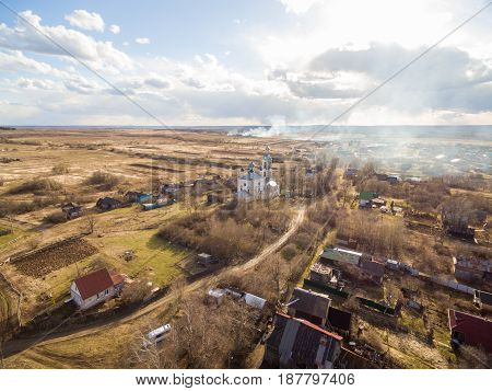 Beautiful russian church with springtime landscape and cloudy sky as seen from air