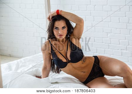 Beautiful brunette girl sexy fitness in lingerie posing in the room interior, bright bedroom