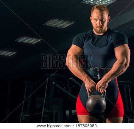 Handsome Athlete Stands With A Weight In His Hands