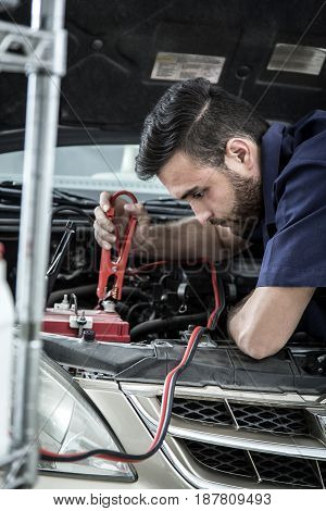 Car Mechanic Man At The Garage Fixing The Engine