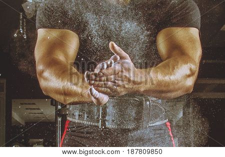 Ahlete Kneels In The Gym And Claps His Hands After Which The Dust From The Chalk Flies