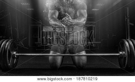 Ahlete Kneels In The Gym And Claps His Hands After Which The Dust From The Chalk Flies