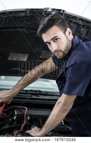 Car Mechanic Man At The Garage Fixing The Engine