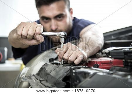 Car Mechanic Man At The Garage Fixing The Engine