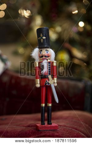 Nutcracker standing in front of Christmas tree