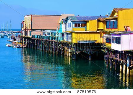 Monterey Bay Warf with colorful buildings which hosts retail stores and restaurants taken in Monterey, CA