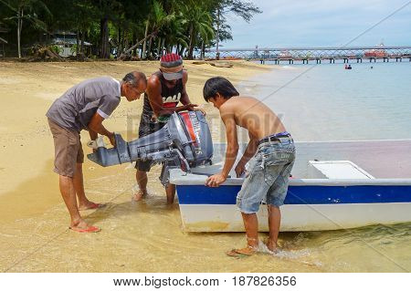 Labuan,Malaysia-Feb 19,2017:Fisherman with Yamaha 2 Stroke 15 horse power boat engine,ready to fishing in beach of Papan island at Labuan,Malaysia.The 15F is a standout in Yamaha's portable range,lightweight and easy to transport.
