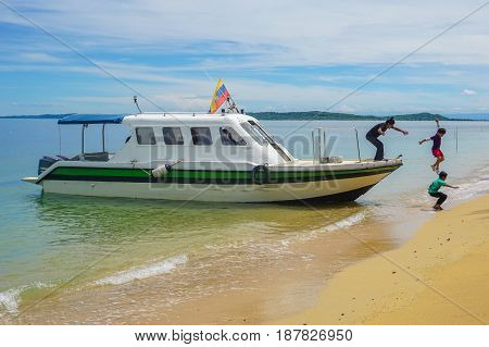 Labuan,Malaysia-Feb 19,2017:Kids jumping off the boat into a beautiful sandy beach of Papan island in Labuan,Malaysia.Having fun on a summer vacation at the beach with friends