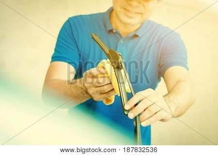 A man cleaning car windscreen (windshield) wiper - car detailing and valeting concept